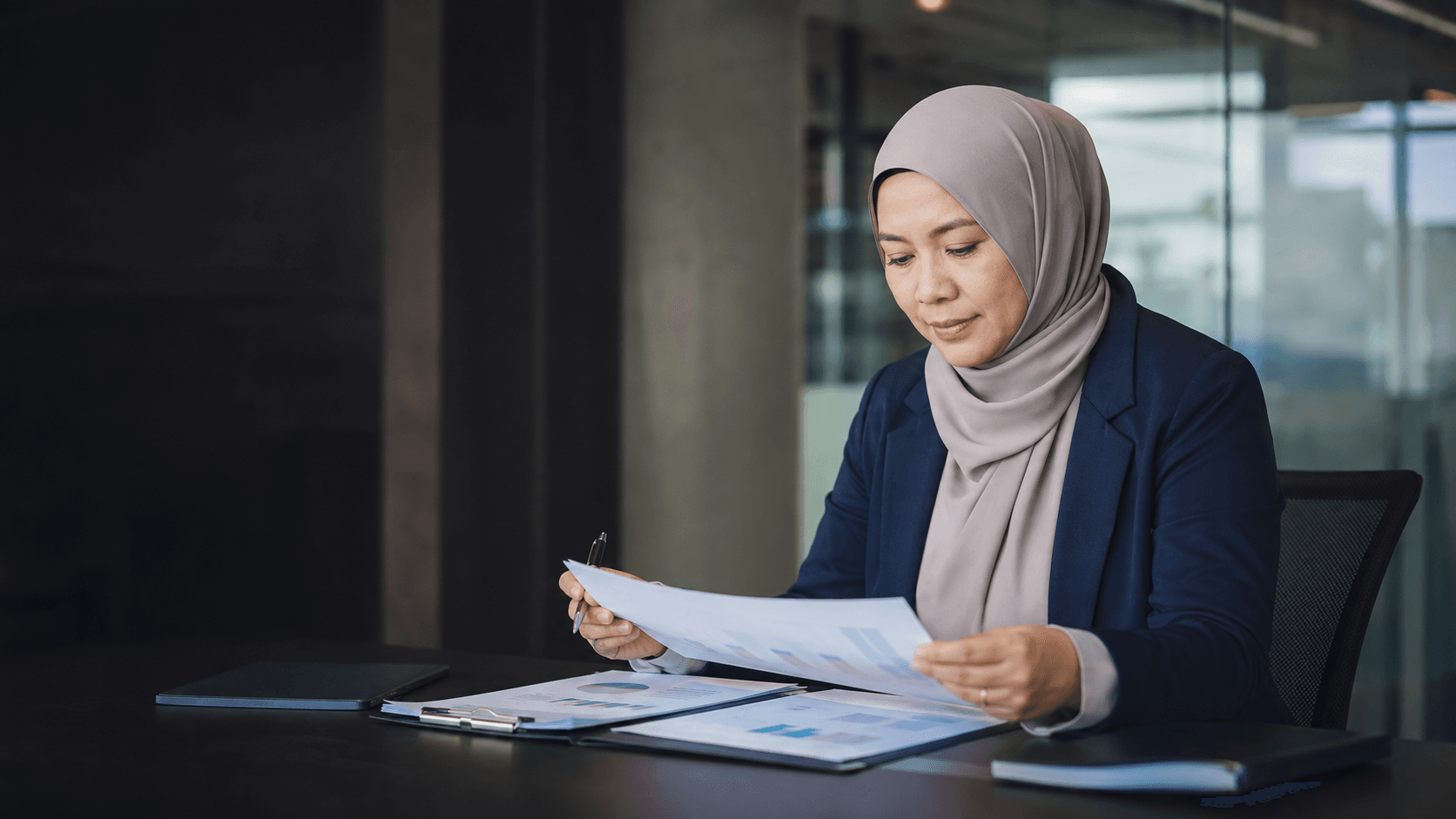 Finance professional reviewing portfolio documents in a modern office